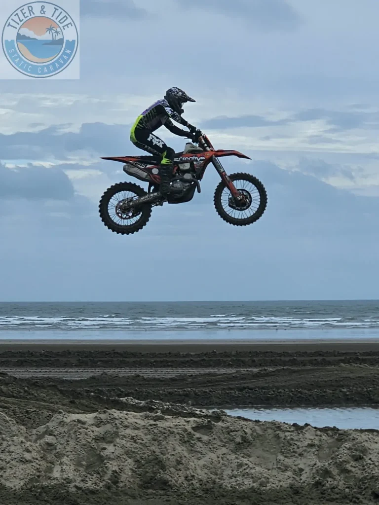 Motocross rider airborne over Pendine beach with the sea behind