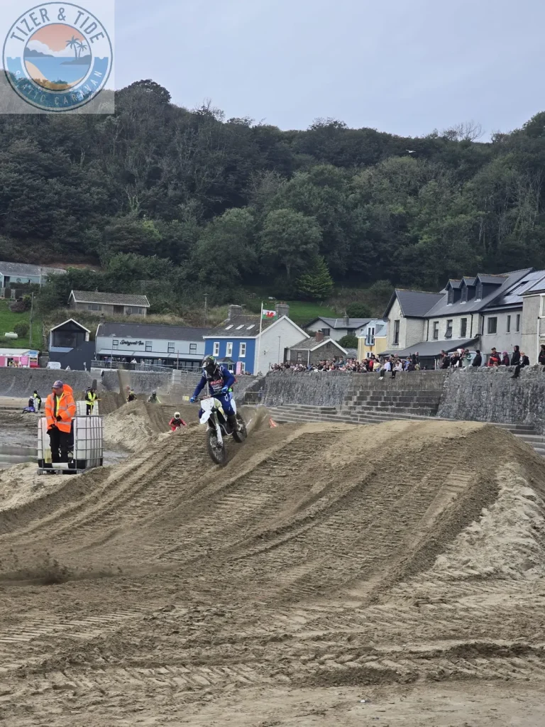 Motocross rider on the sand track with Pendine village behind
