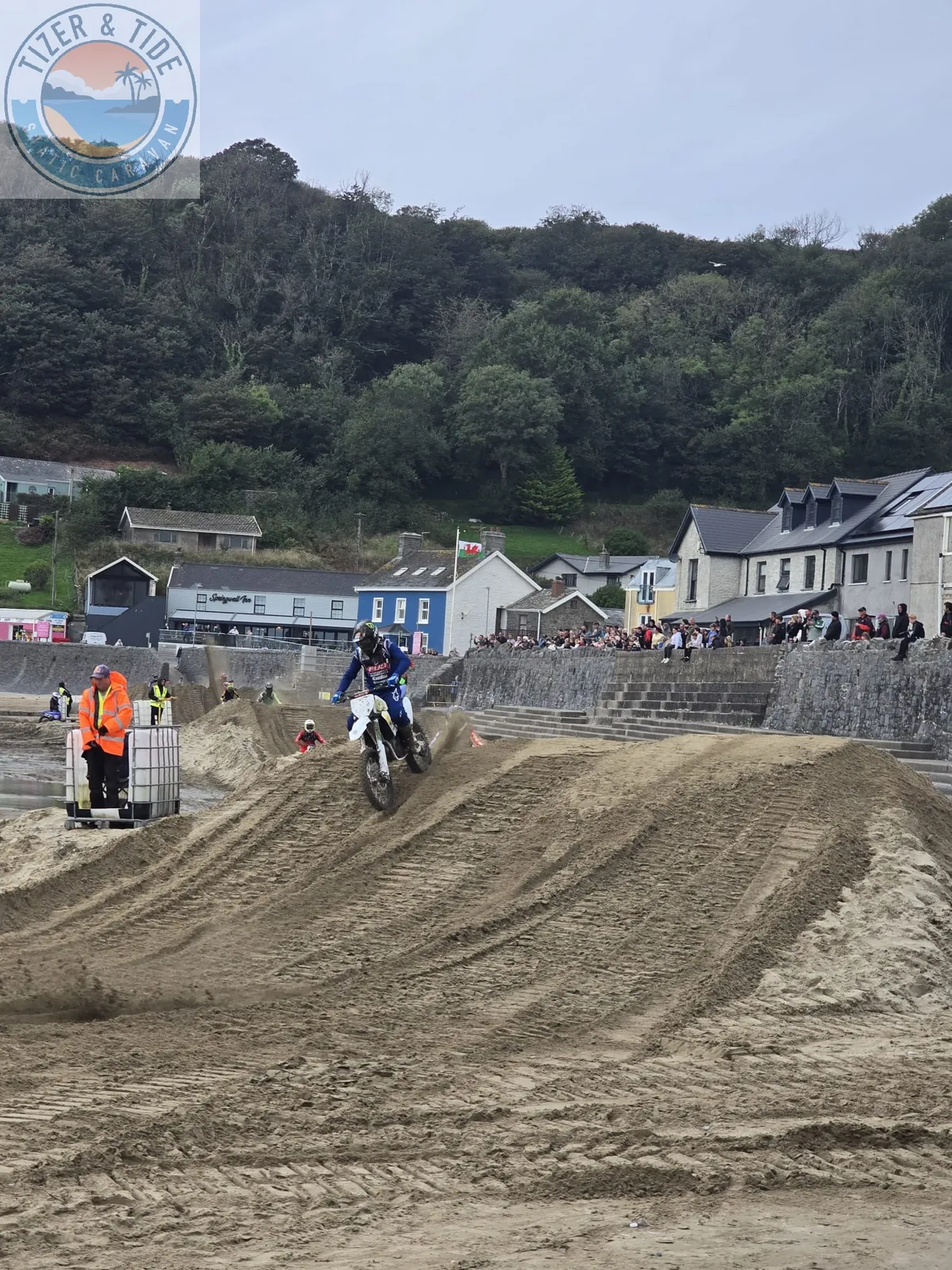 Motocross rider on the sand track with Pendine village behind